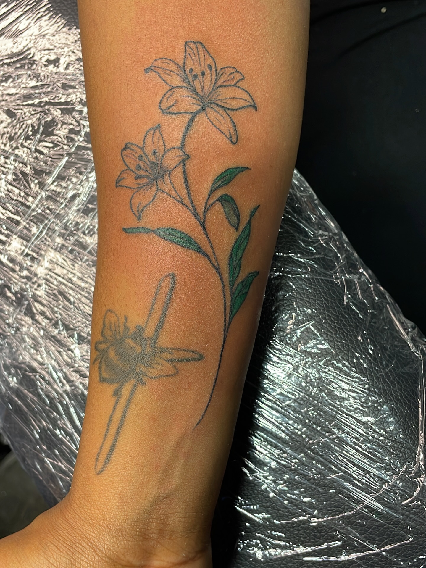 Lily and dragonfly black and grey tattoo on the forearm by Vanessa - Dallas Artist