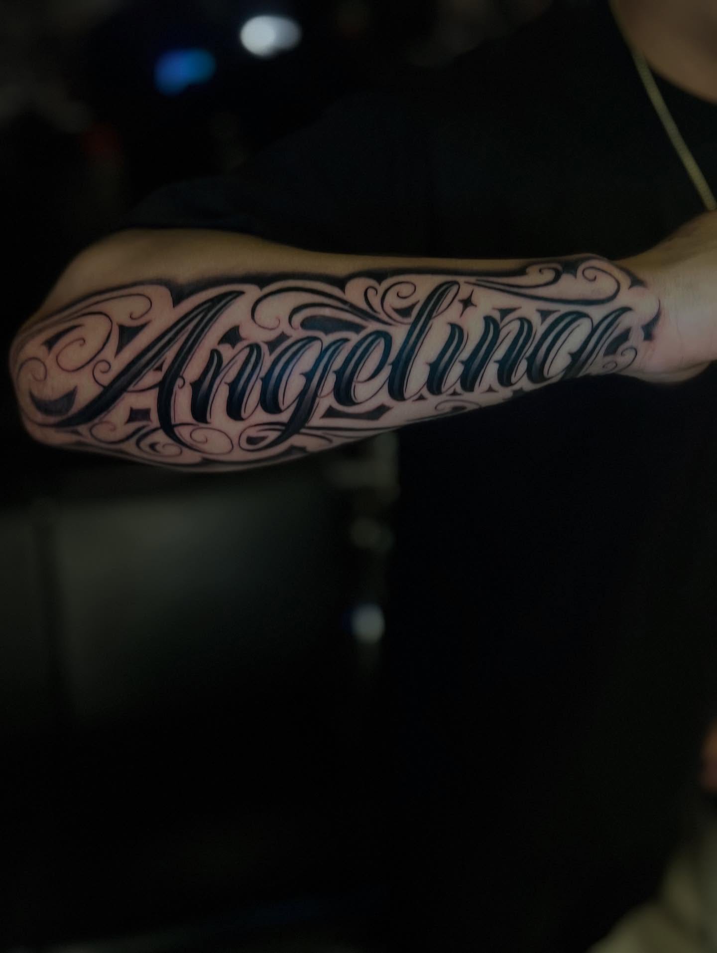 Angelina lettering script tattoo on the forearm by Kevyn Vidal