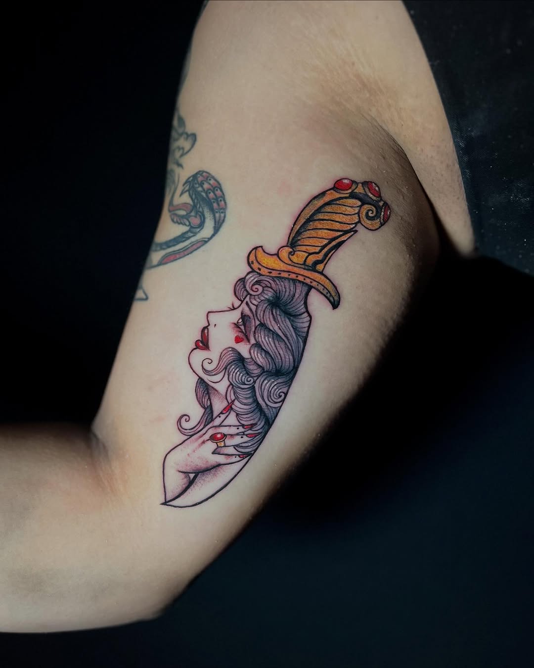 Woman's head on a dagger American traditional tattoo on the forearm by Sasha “Sashimi” Shabasov