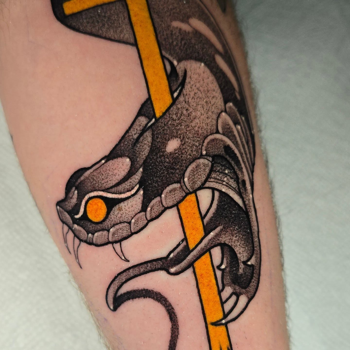 Snake American traditional tattoo on the forearm by Justin Eldridge