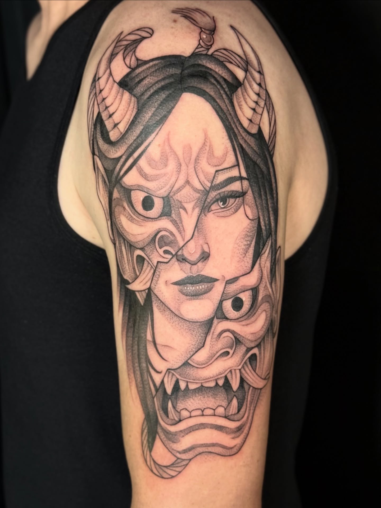 Woman with demon mask realism tattoo on the forearm by Miles Romero Smith