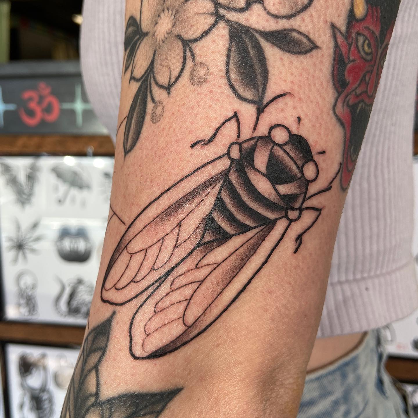 Cicada black and grey tattoo on the forearm by Lucía