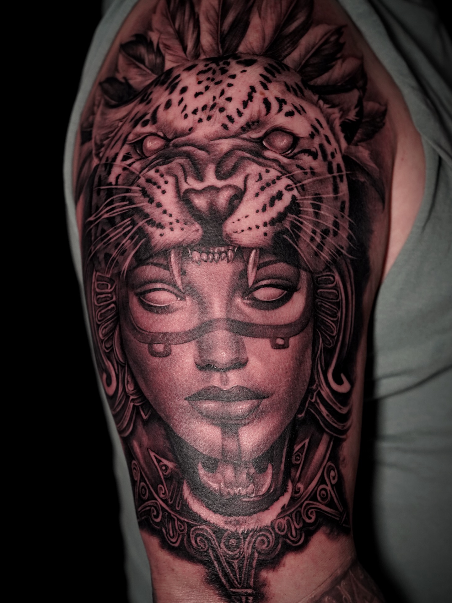 Woman with leopard realism tattoo on the shoulder by tombstone