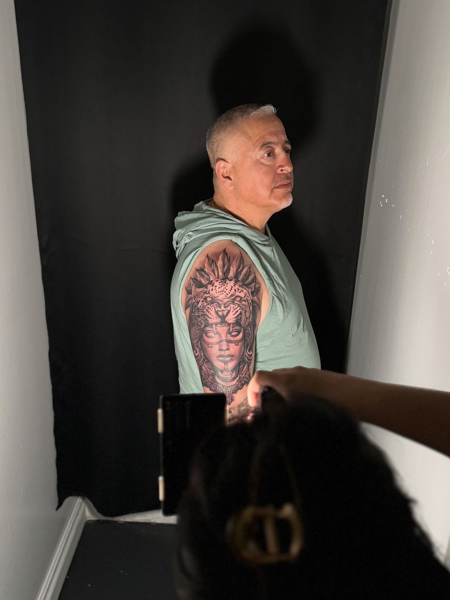 Woman's face American traditional tattoo on the upper arm by tombstone