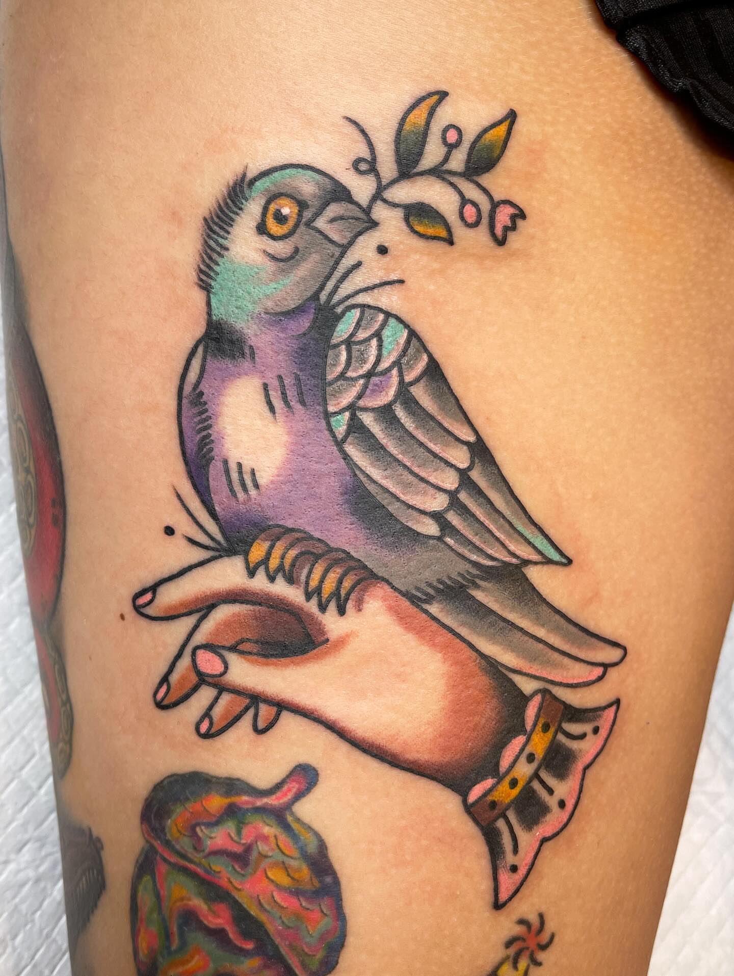 Bird and hand American traditional tattoo on the thigh by Josh Brownell
