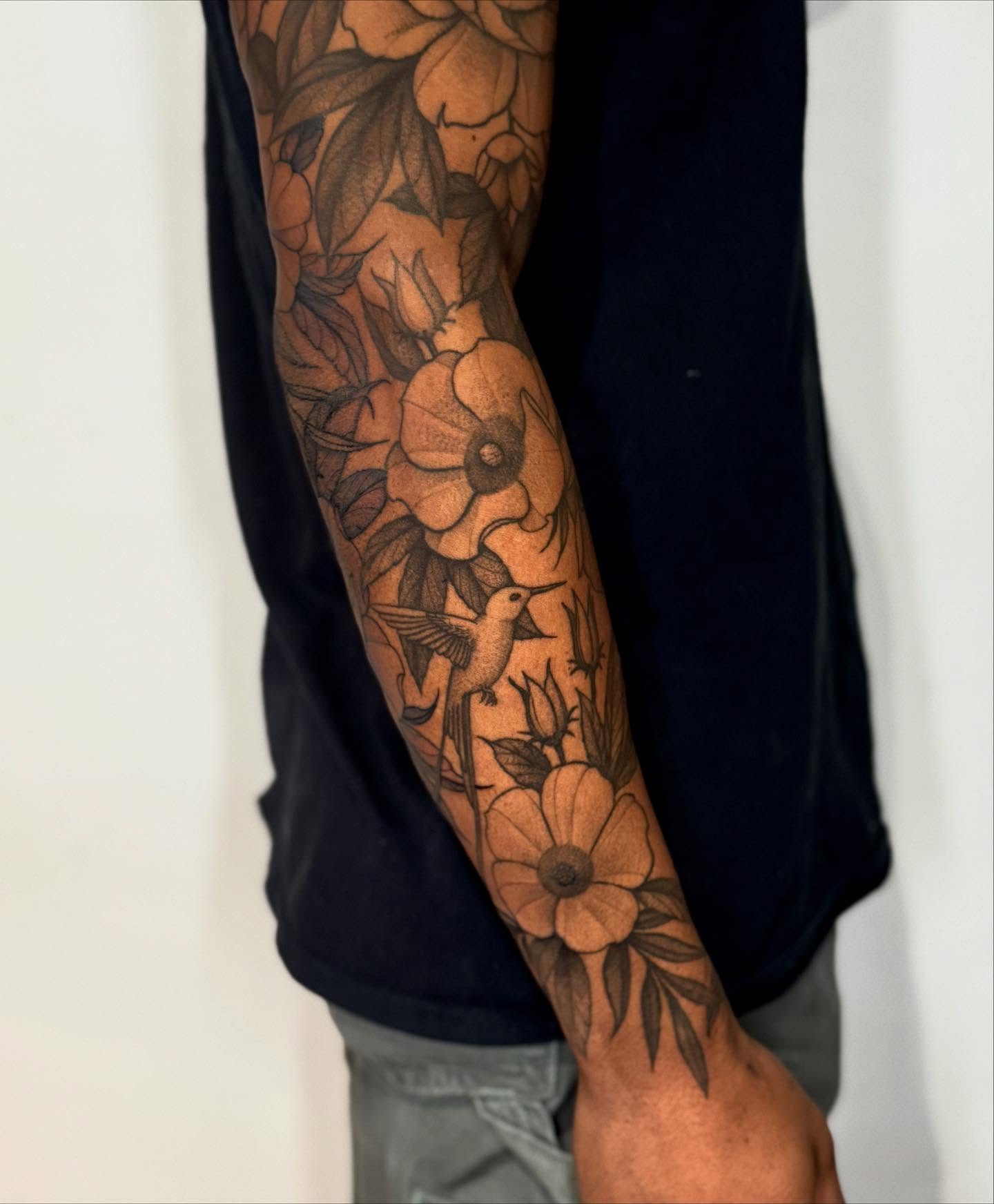 Flowers and hummingbird black and grey tattoo on the forearm by Lauren Llerandi