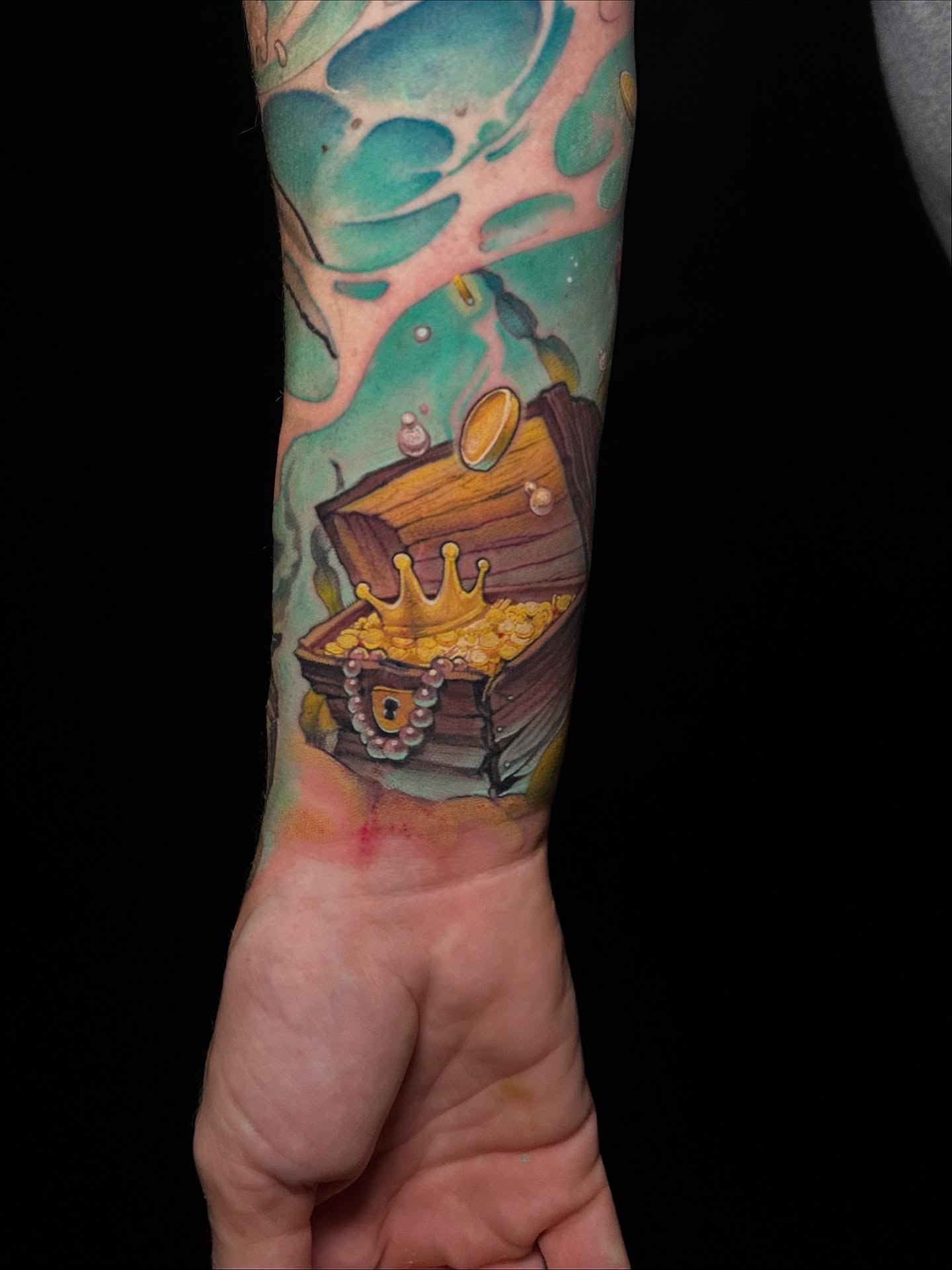 Treasure chest watercolor tattoo on the forearm by Jake Kirk