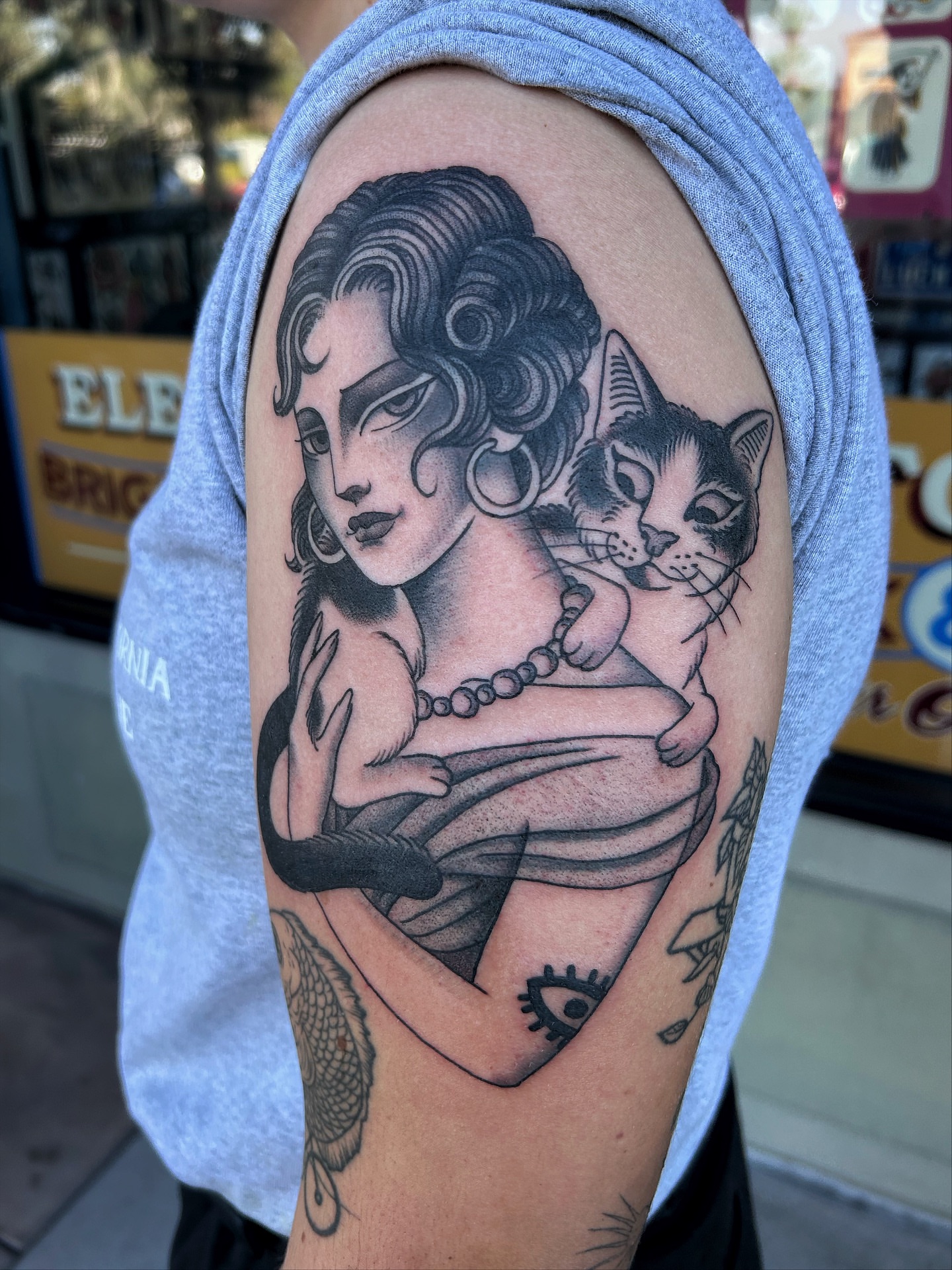 Woman with cat American traditional tattoo on the shoulder by Jade McKenzie, Temecula, California