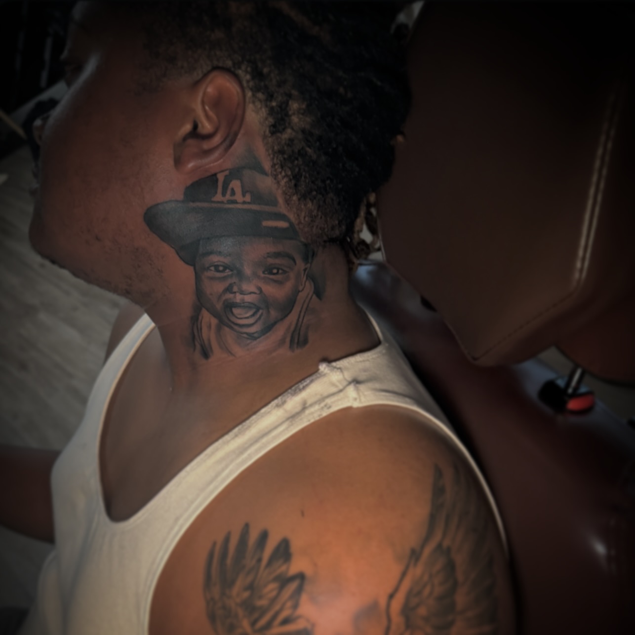 Child wearing hat realism tattoo on the neck by Jared McGee