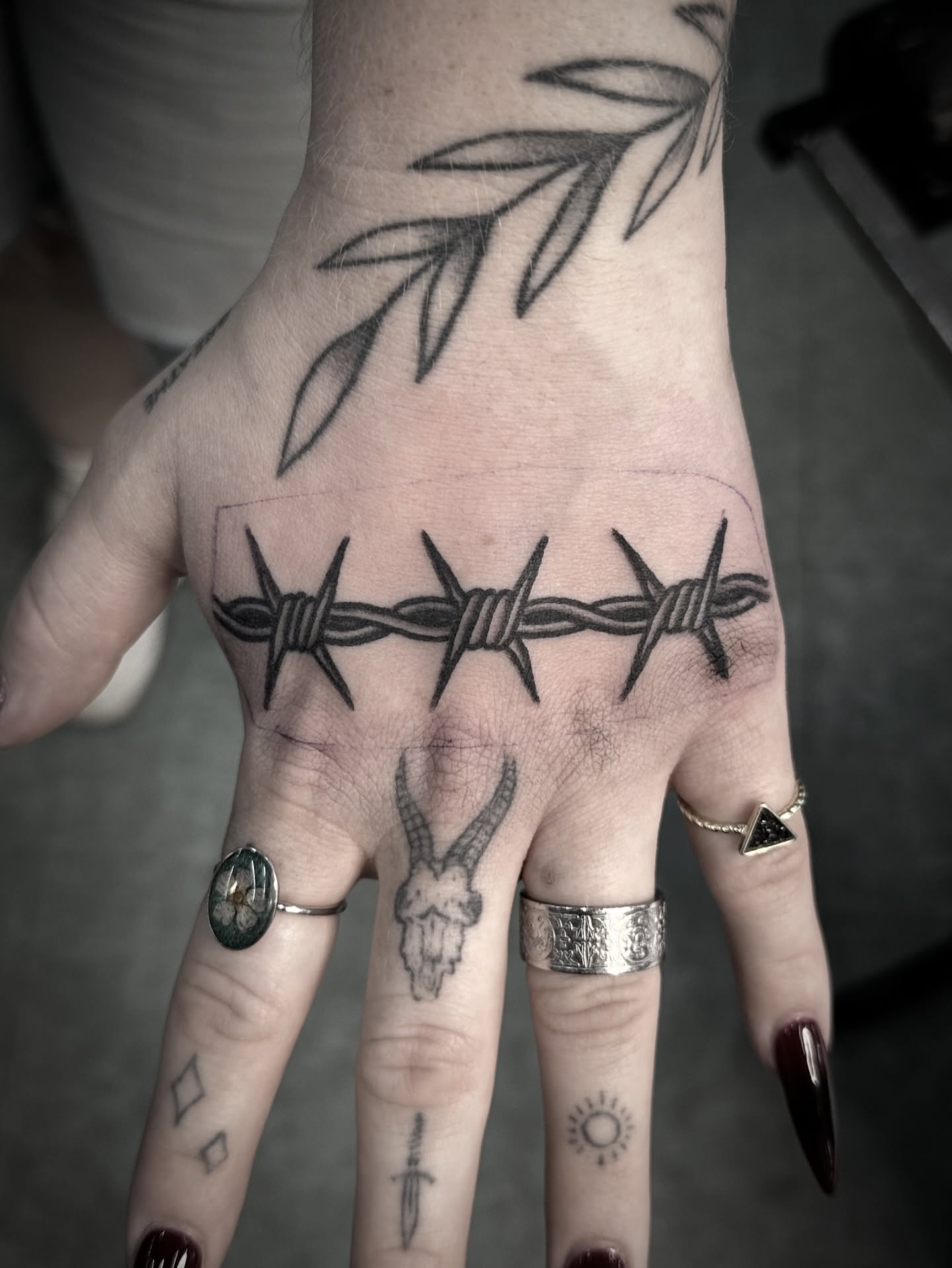 Barbed wire black and grey tattoo on the hand by Chris Blanchard