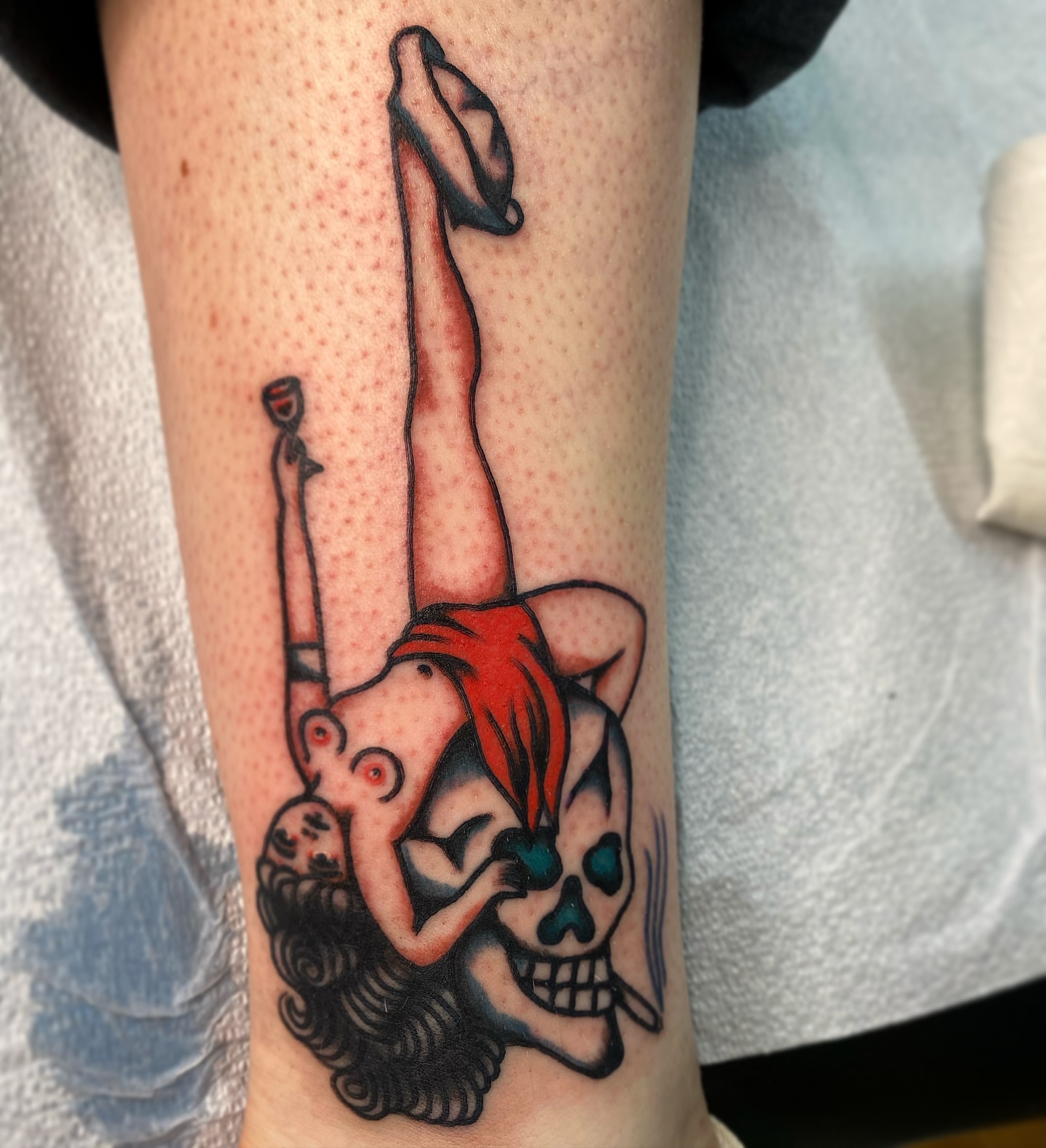 Pin-up girl with skull American traditional tattoo on the forearm by Joey Delarosa, San Francisco, California