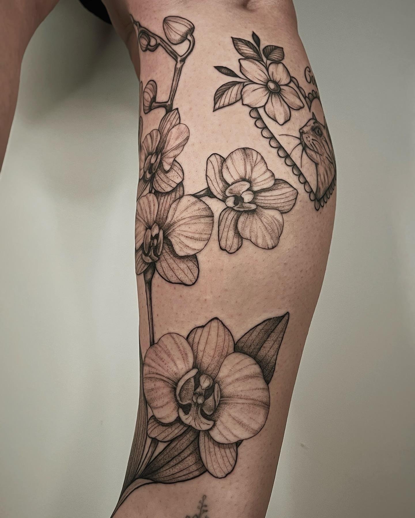 Orchids realism tattoo on the thigh by Mikayla Sue