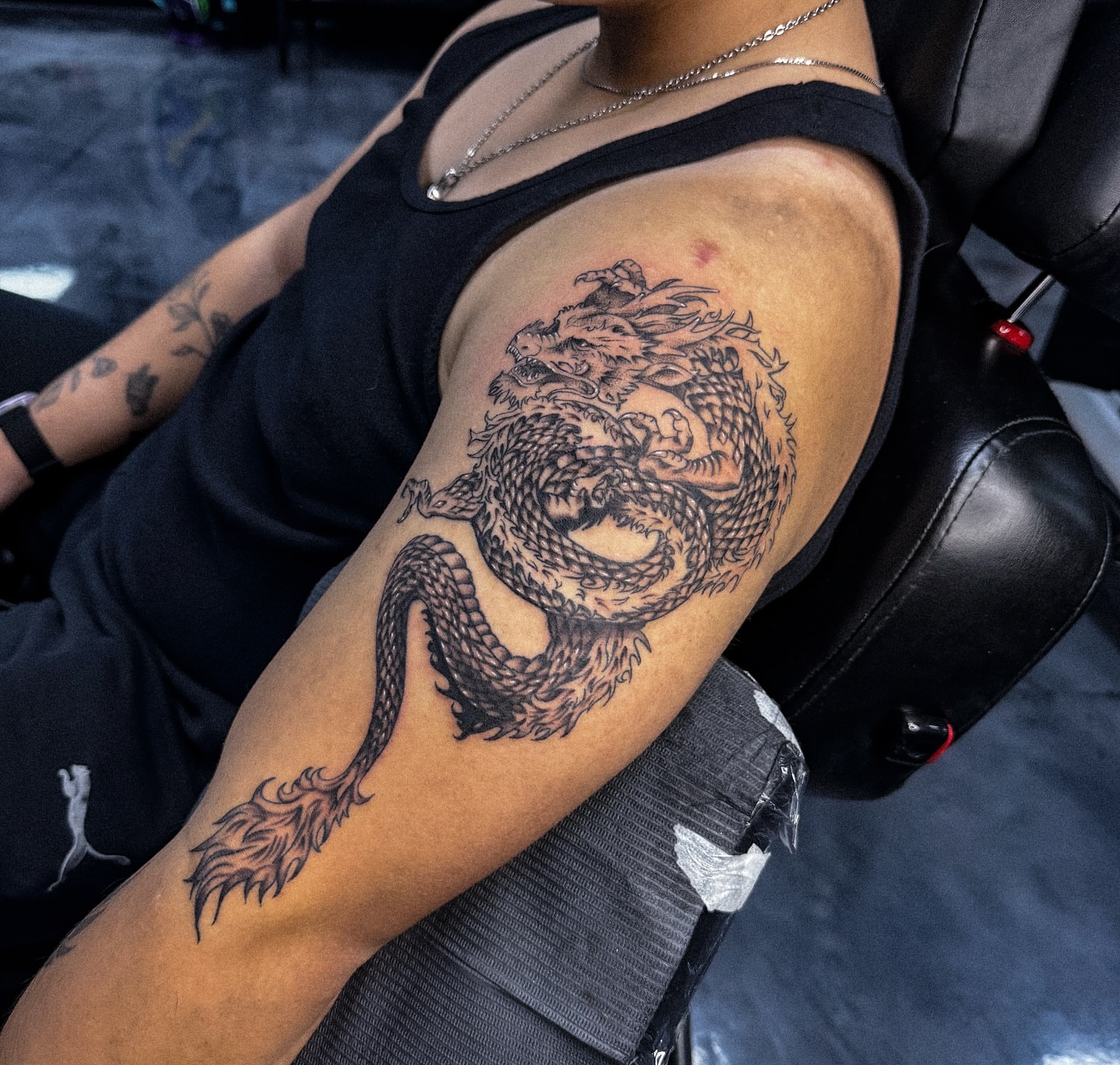 Dragon black and grey tattoo on the upper arm by Marie Amor🌙