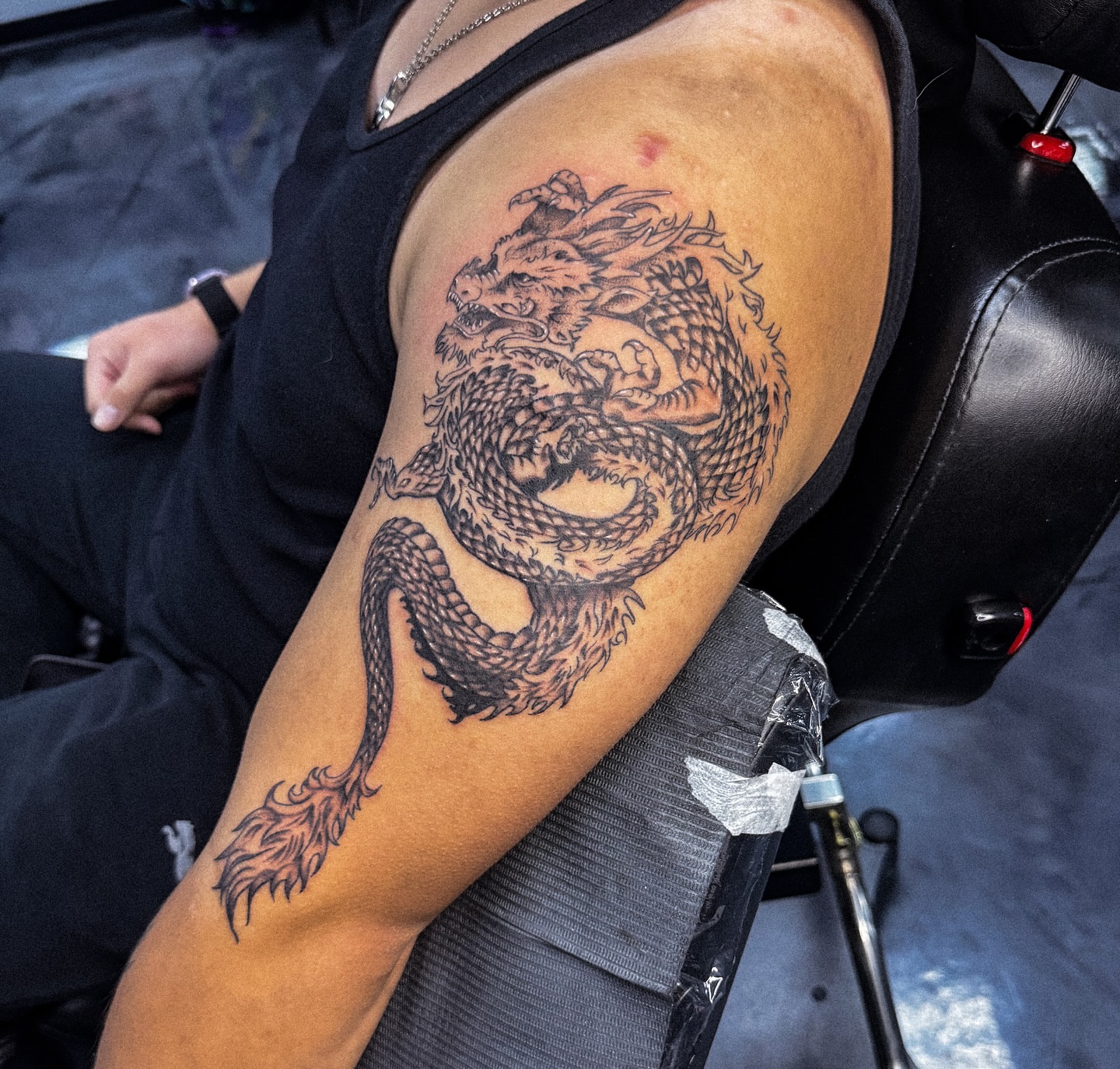 Dragon black and grey tattoo on the upper arm by Marie Amor🌙