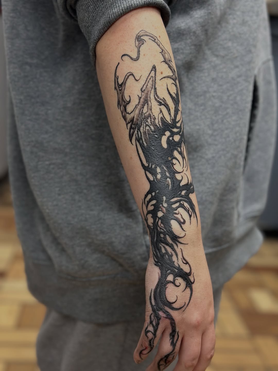 Abstract dark tendrils blackwork tattoo on the forearm by vannadoestattoos