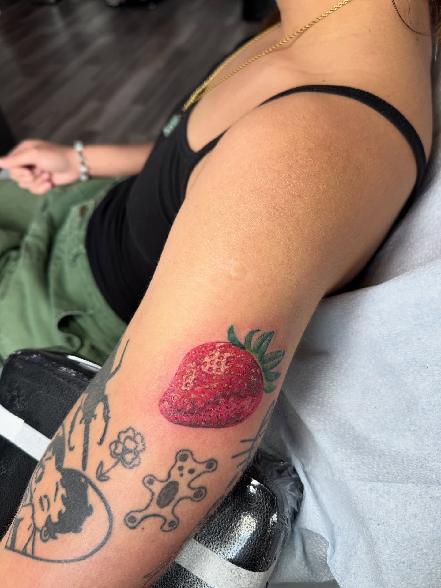 Strawberry realism tattoo on the forearm by Nathalie Briseno