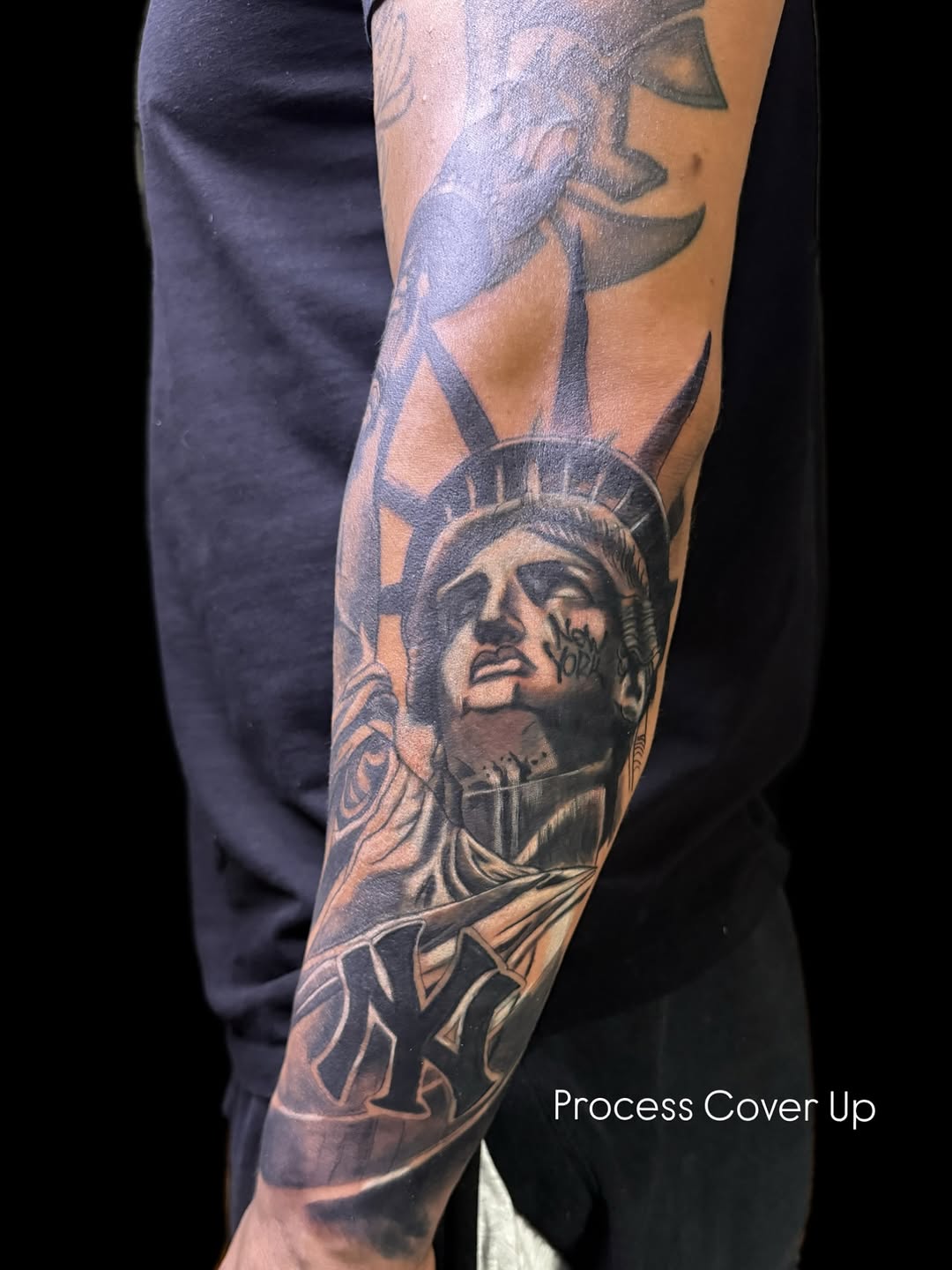 Statue of liberty and ny yankees logo realism tattoo on the forearm by German Patiño.