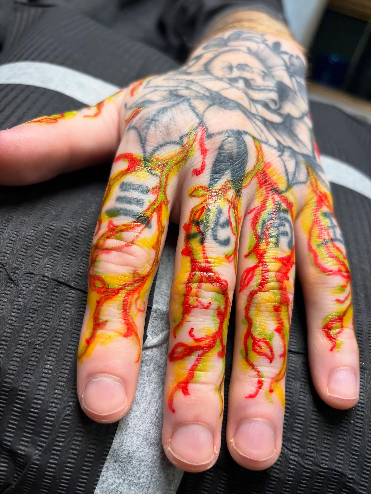 Flame and text dotwork tattoo on the hand by Rachel Foster