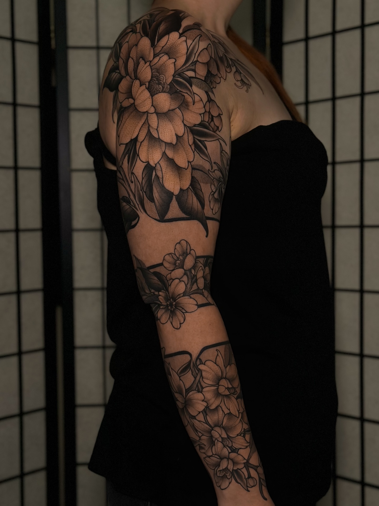 Floral bouquet black and grey tattoo on the upper arm by San Diego