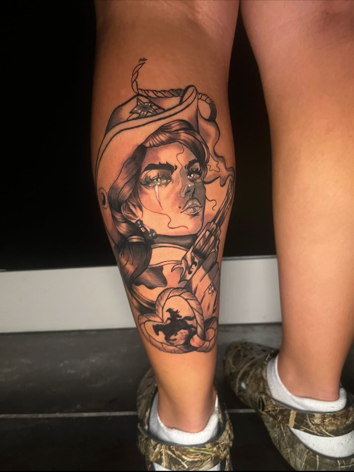 Woman with cowboy hat American traditional tattoo on the calf by Deville Pinson