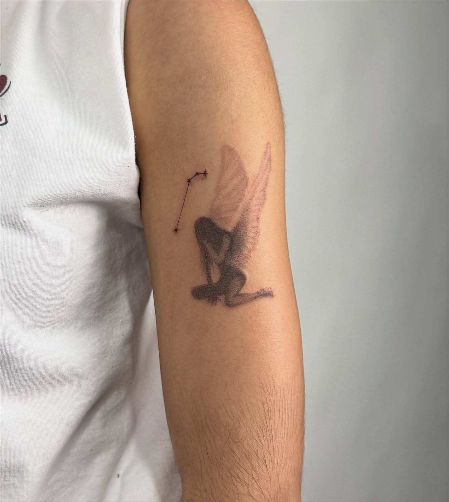 Angel with bow black and grey tattoo on the forearm by sabina