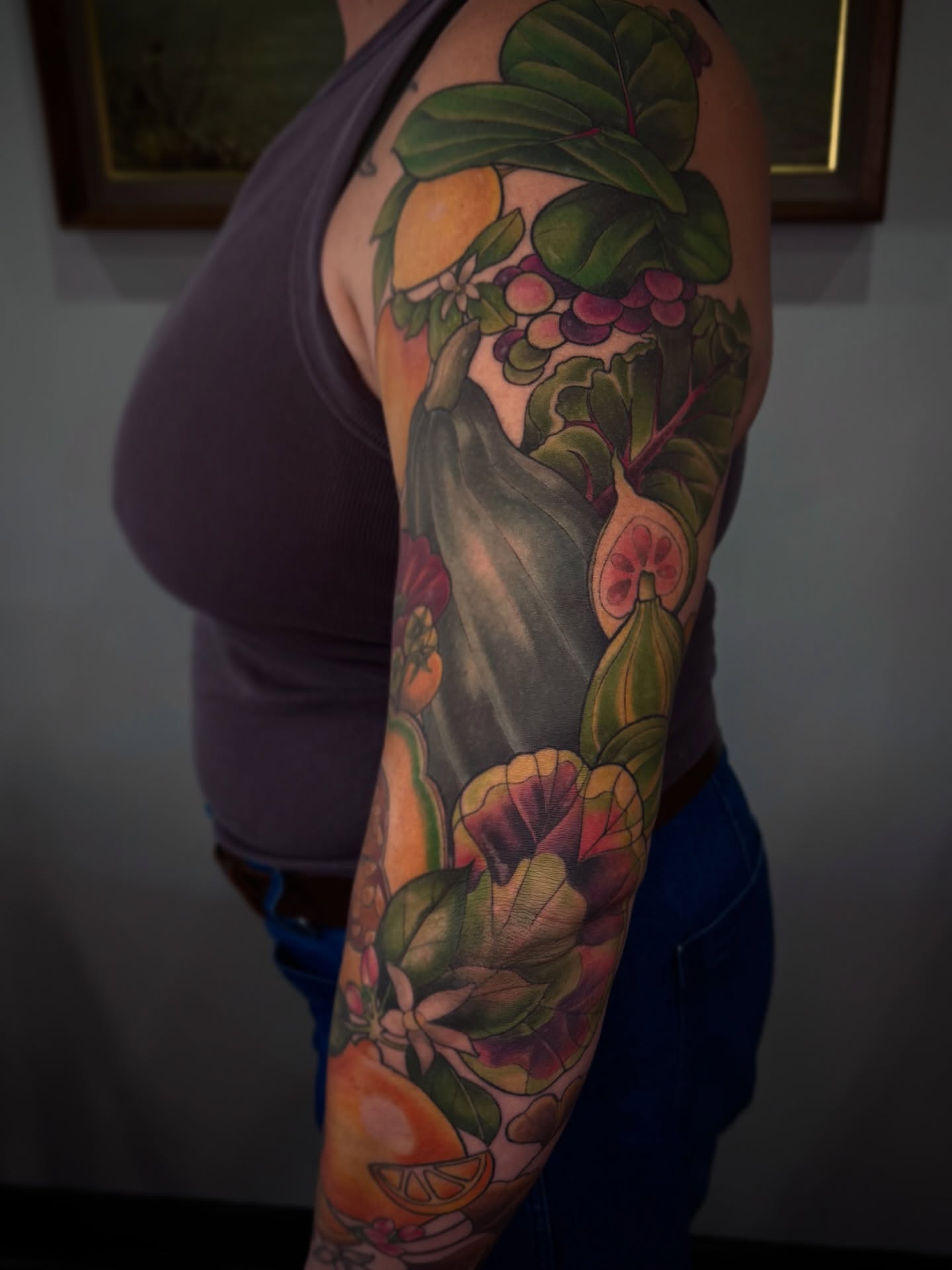 Fruit and floral realism tattoo on the upper arm by Alyssa Shirkey