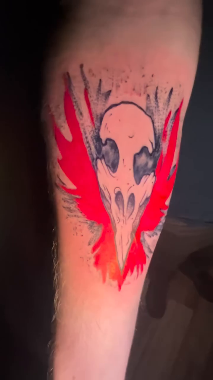 Raven skull with red wings dark art tattoo on the forearm by Davidsteeletattoos, Dallas, Texas