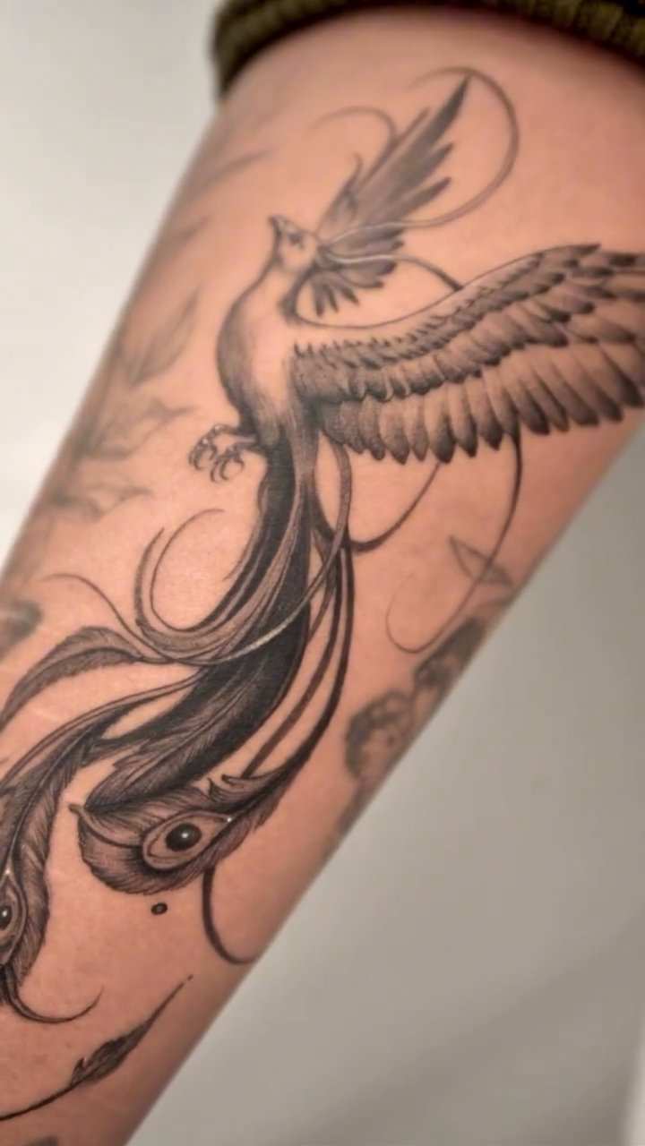 Phoenix with floral elements watercolor tattoo on the forearm by Valentina