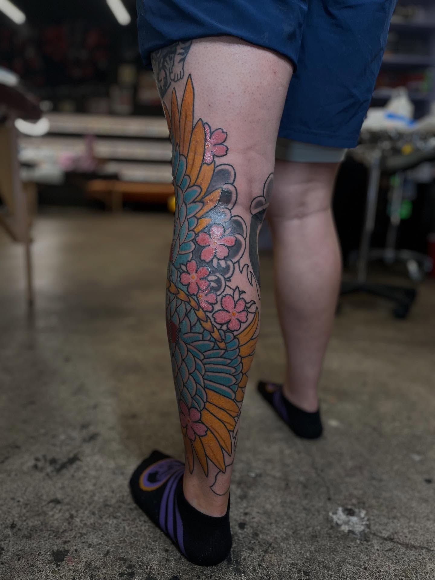 Cherry blossoms and leaves American traditional tattoo on the leg by Kaichi Fujita, Eugene, Oregon