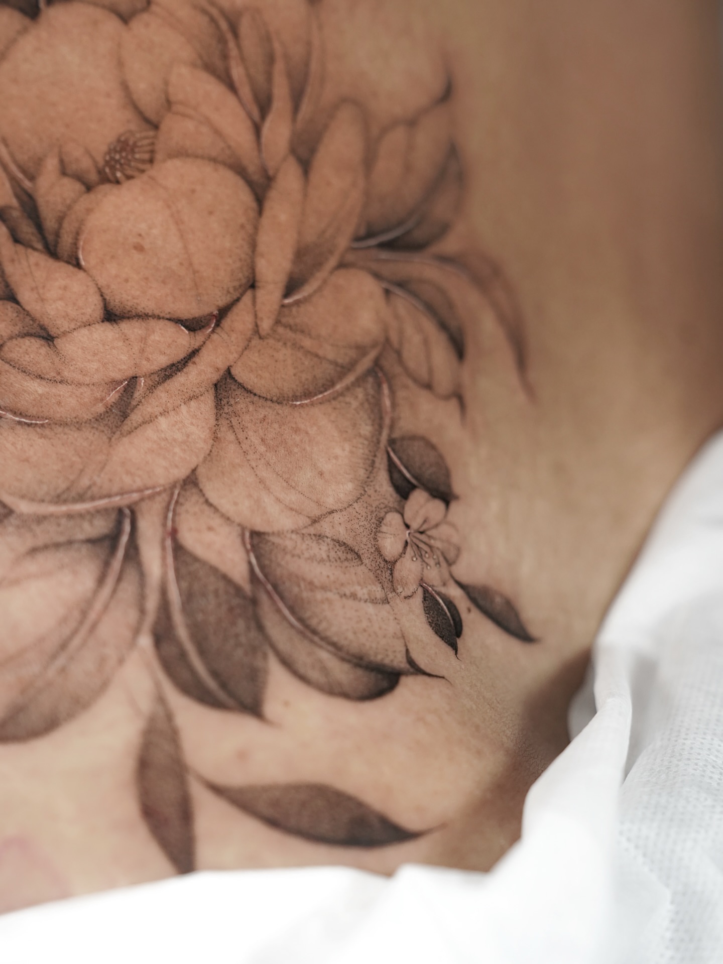 Flower black and grey tattoo on the chest by Bel Fernandez