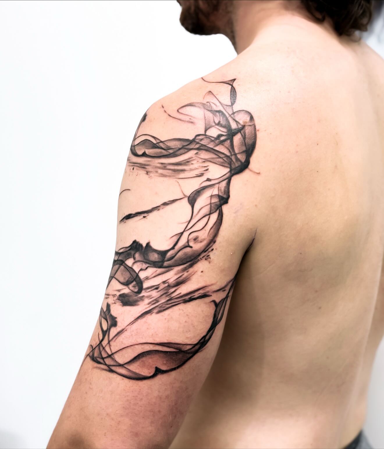 Smoke black and grey tattoo on the shoulder by Banky