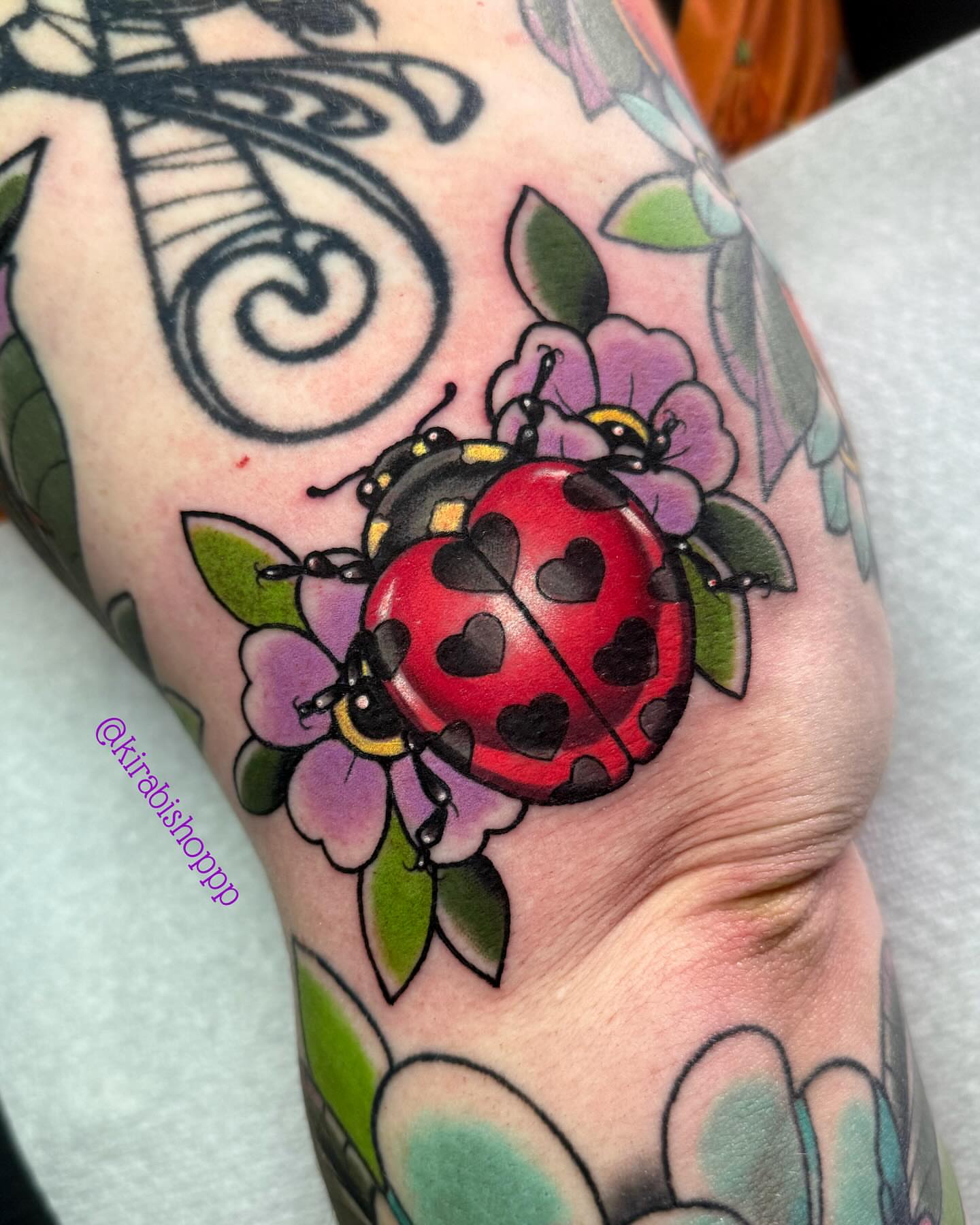Ladybug and flower American traditional tattoo on the forearm by 𝔎𝔦𝔯𝔞 𝔅𝔦𝔰𝔥𝔬𝔭