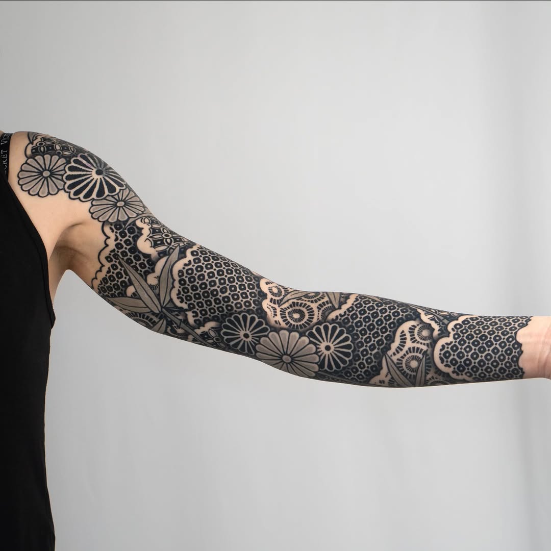 Floral and geometric patterns geometric tattoo on the upper arm by Kevin Ligabue