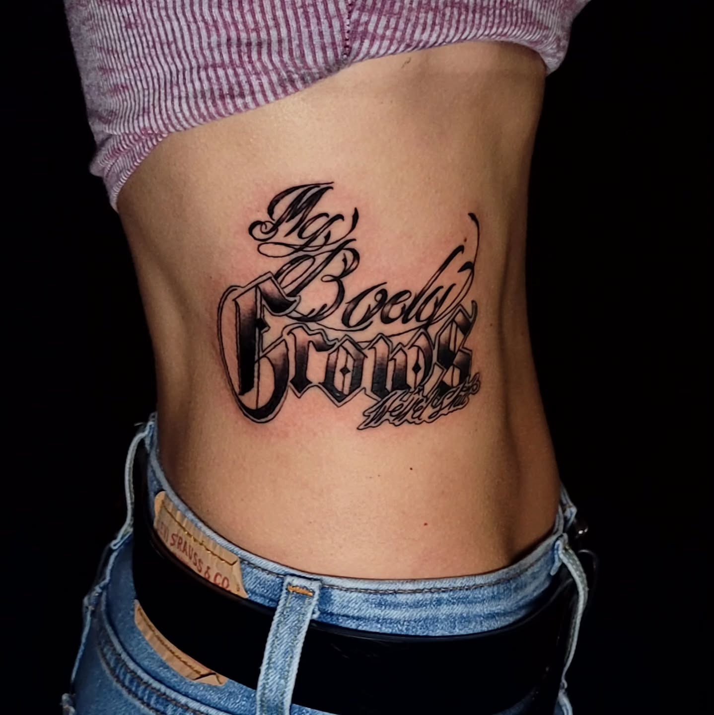 My Body Grows lettering script tattoo on the torso by Tyler Monty