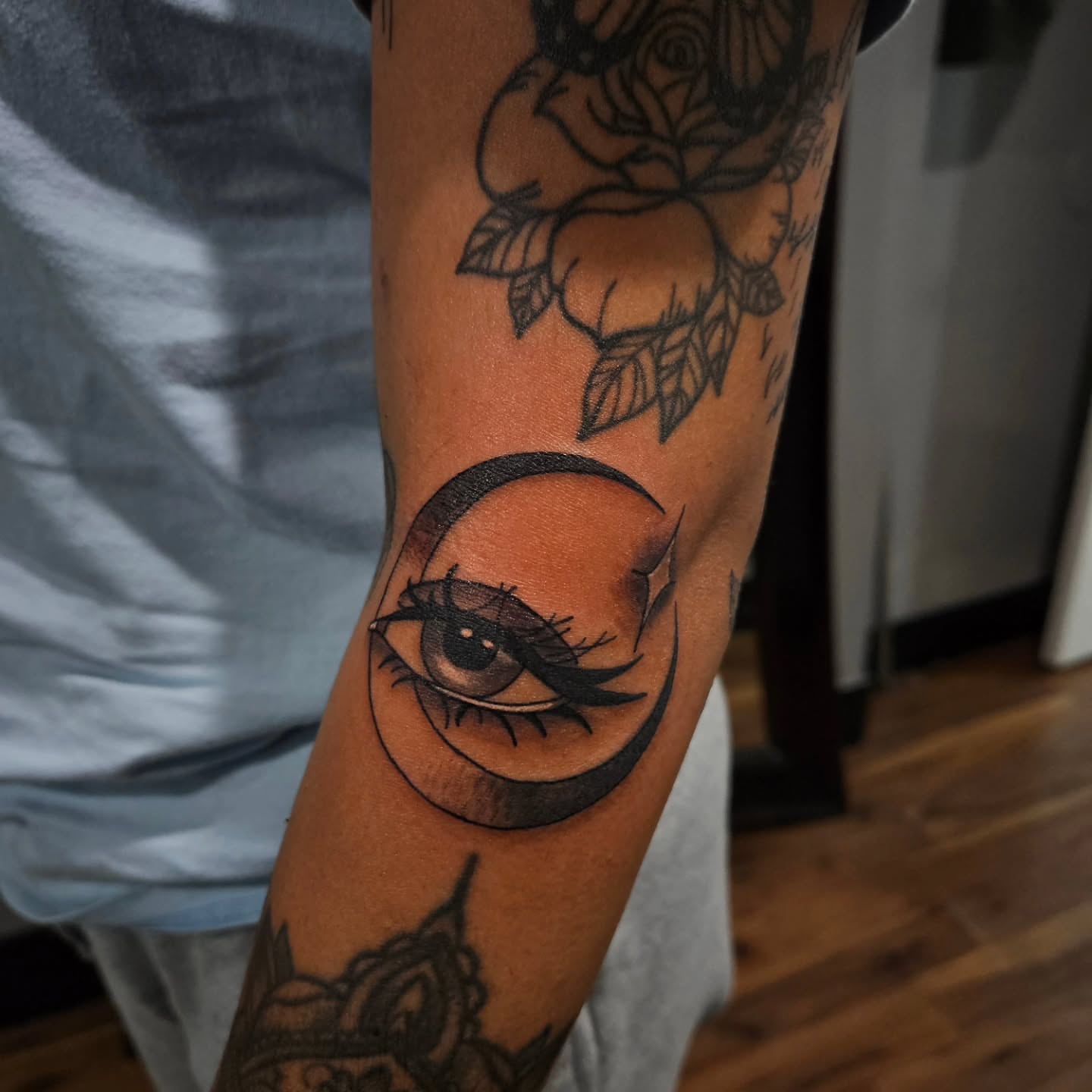Eye within crescent moon black and grey tattoo on the forearm by Danny
