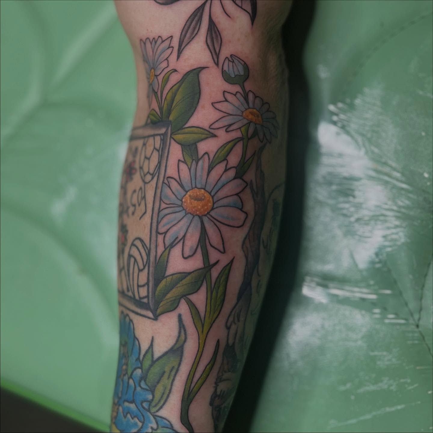 Daisies and leaves new school tattoo on the forearm by Lexi Ross