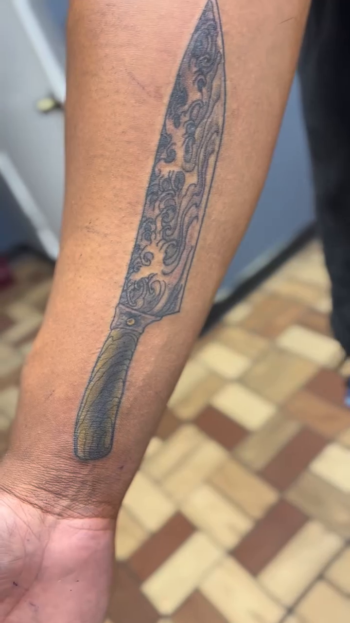 Chef's knife with floral pattern American traditional tattoo on the forearm by vannadoestattoos