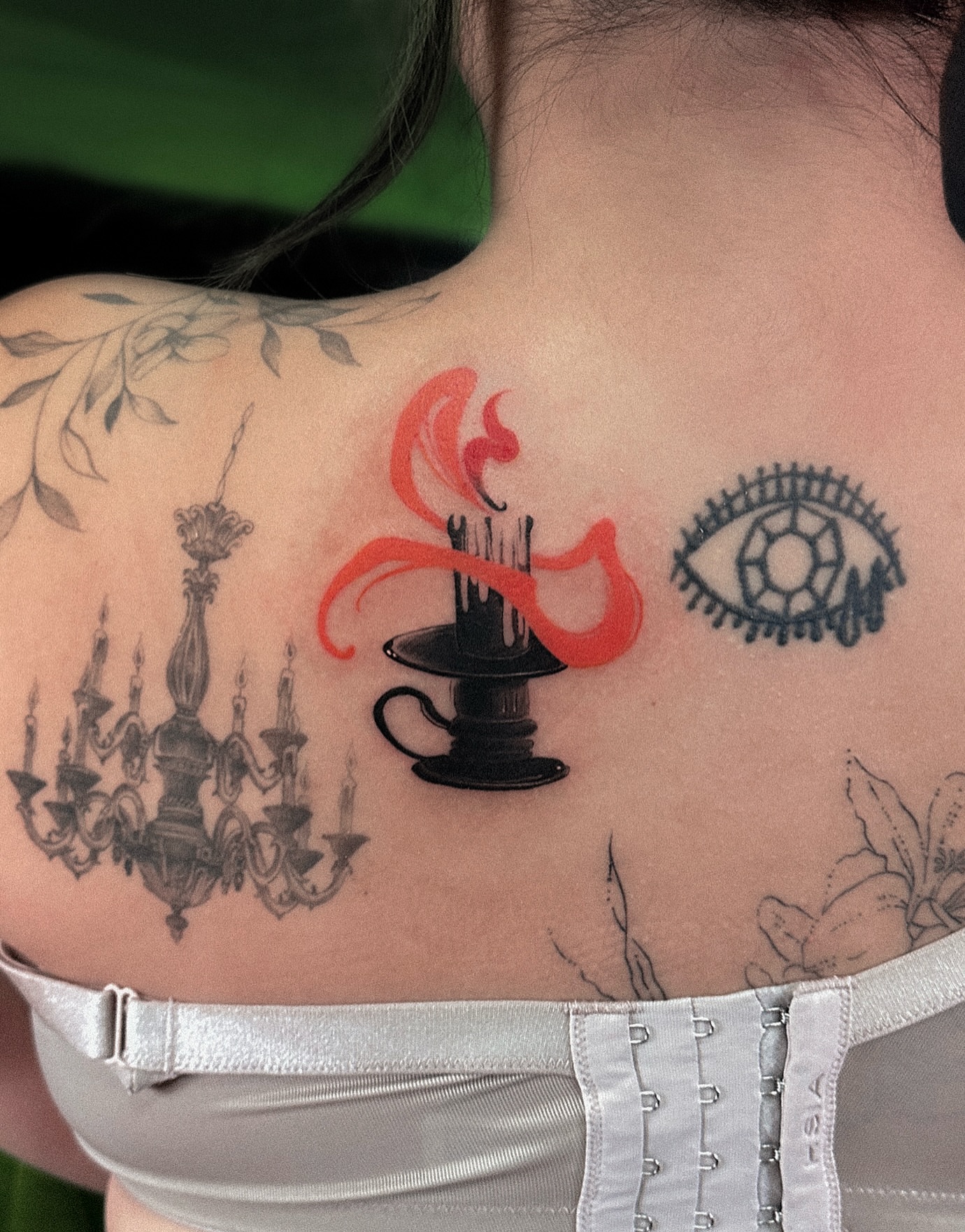 Chandelier, candle, flame, eye black and grey tattoo on the back by Tattoo Artist 👩🏻‍🎨 ATX