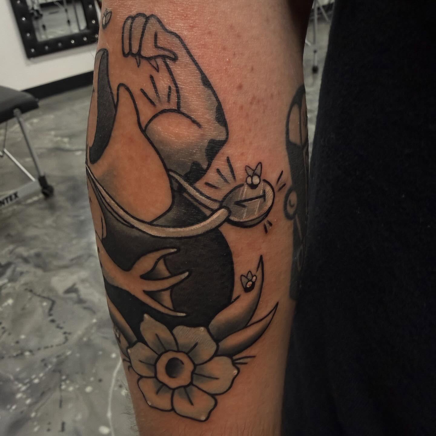 Deer antlers and flower American traditional tattoo on the forearm by Romans