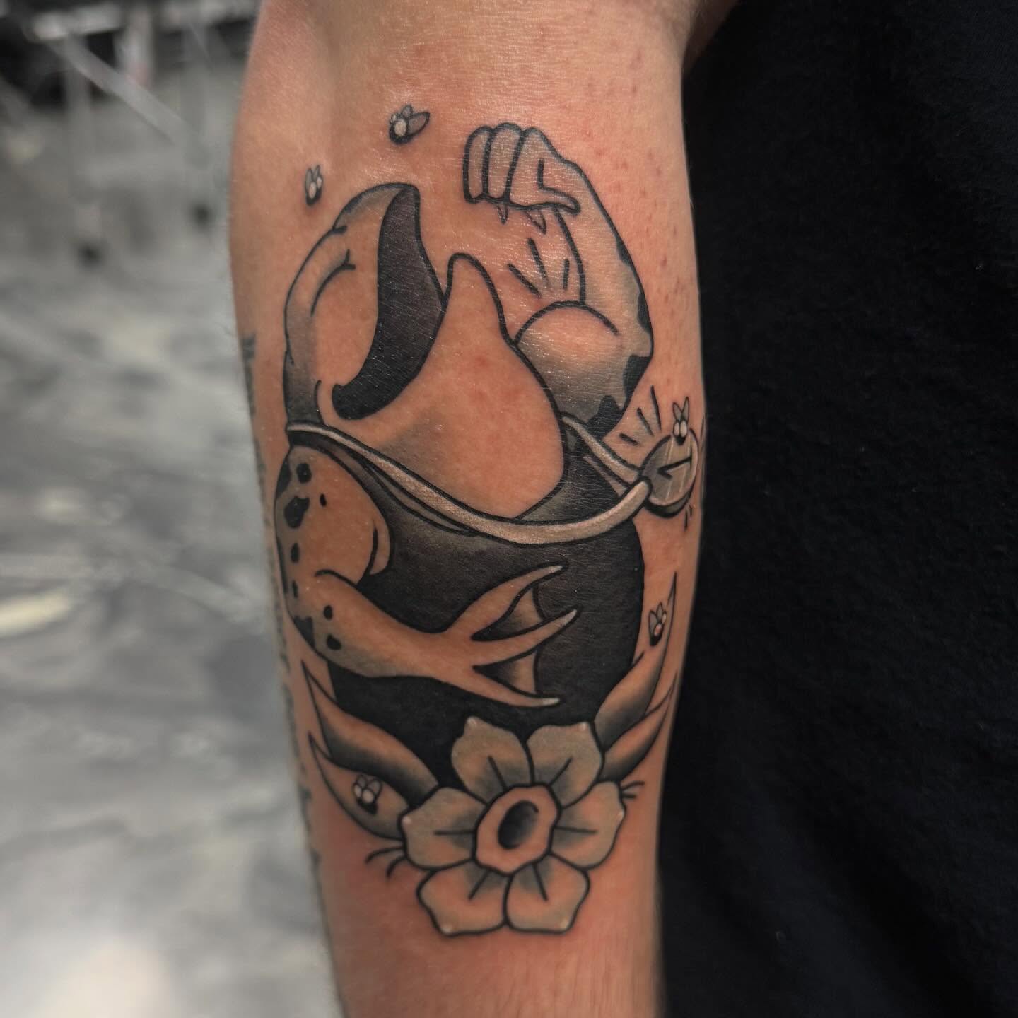 Frog and flower black and grey tattoo on the forearm by Romans