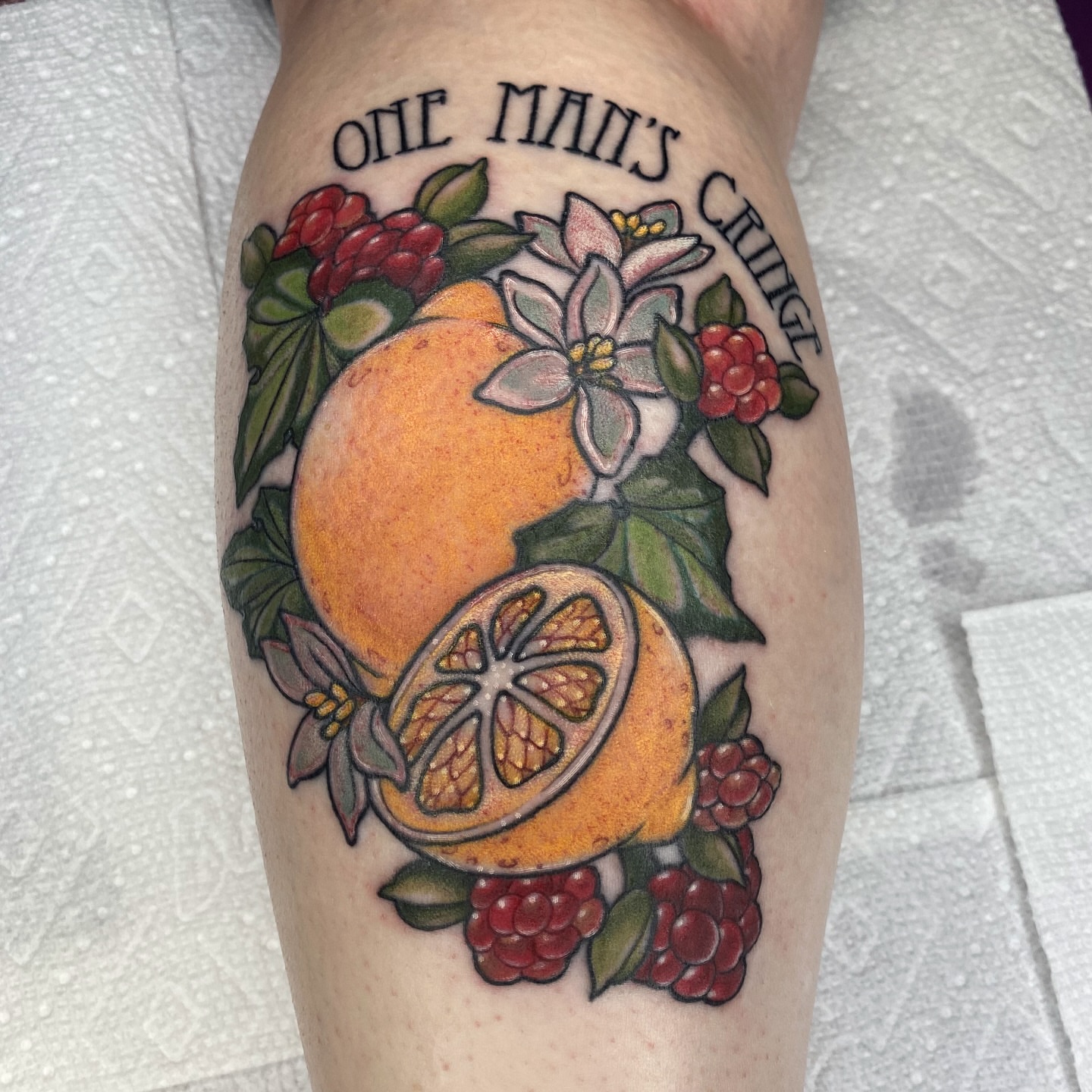 Orange and flowers realism tattoo on the forearm by Tayler Pearson, Fort Collins, Colorado