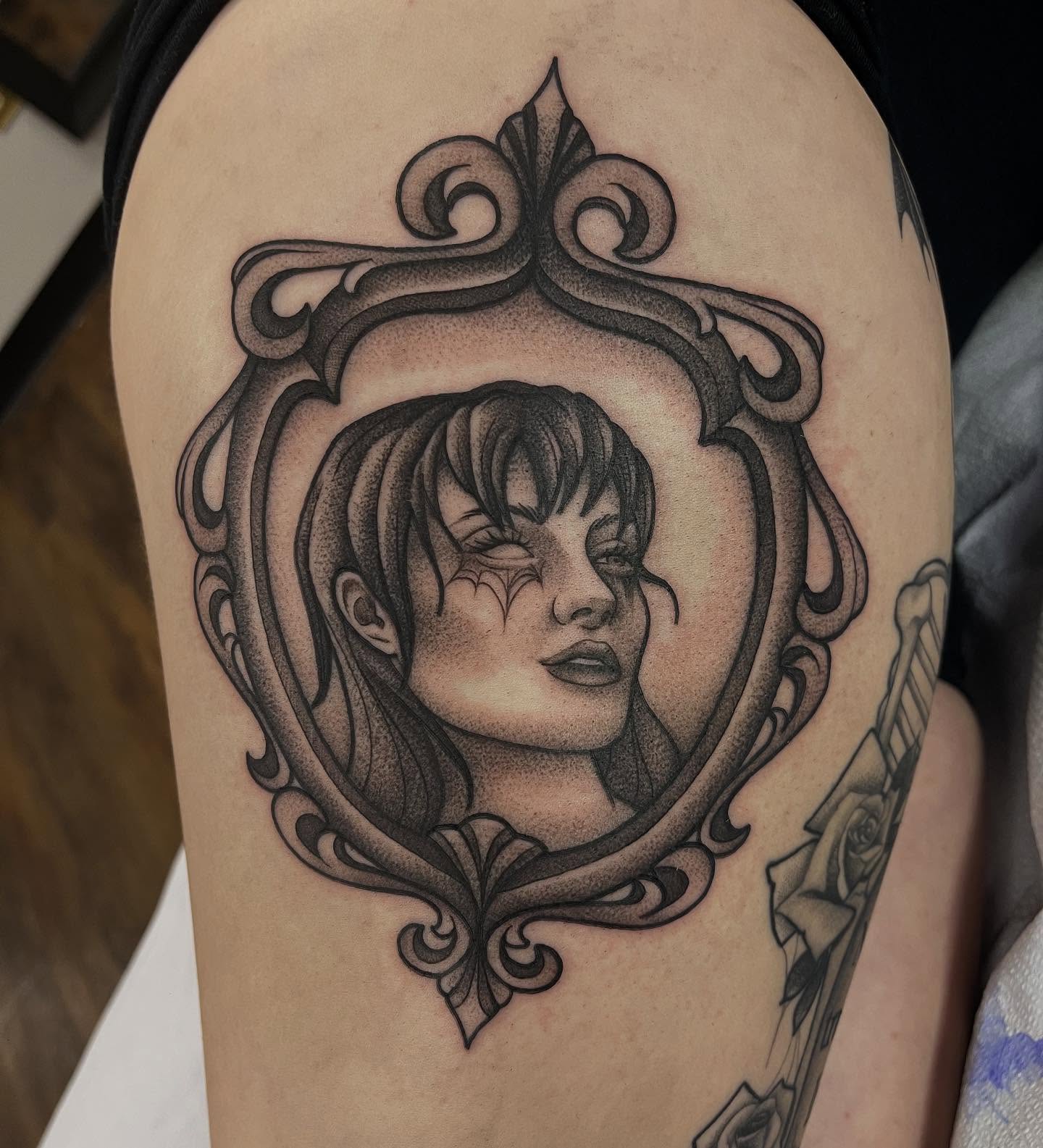 Portrait in ornate frame dotwork tattoo on the thigh by Lauren Bumgardner