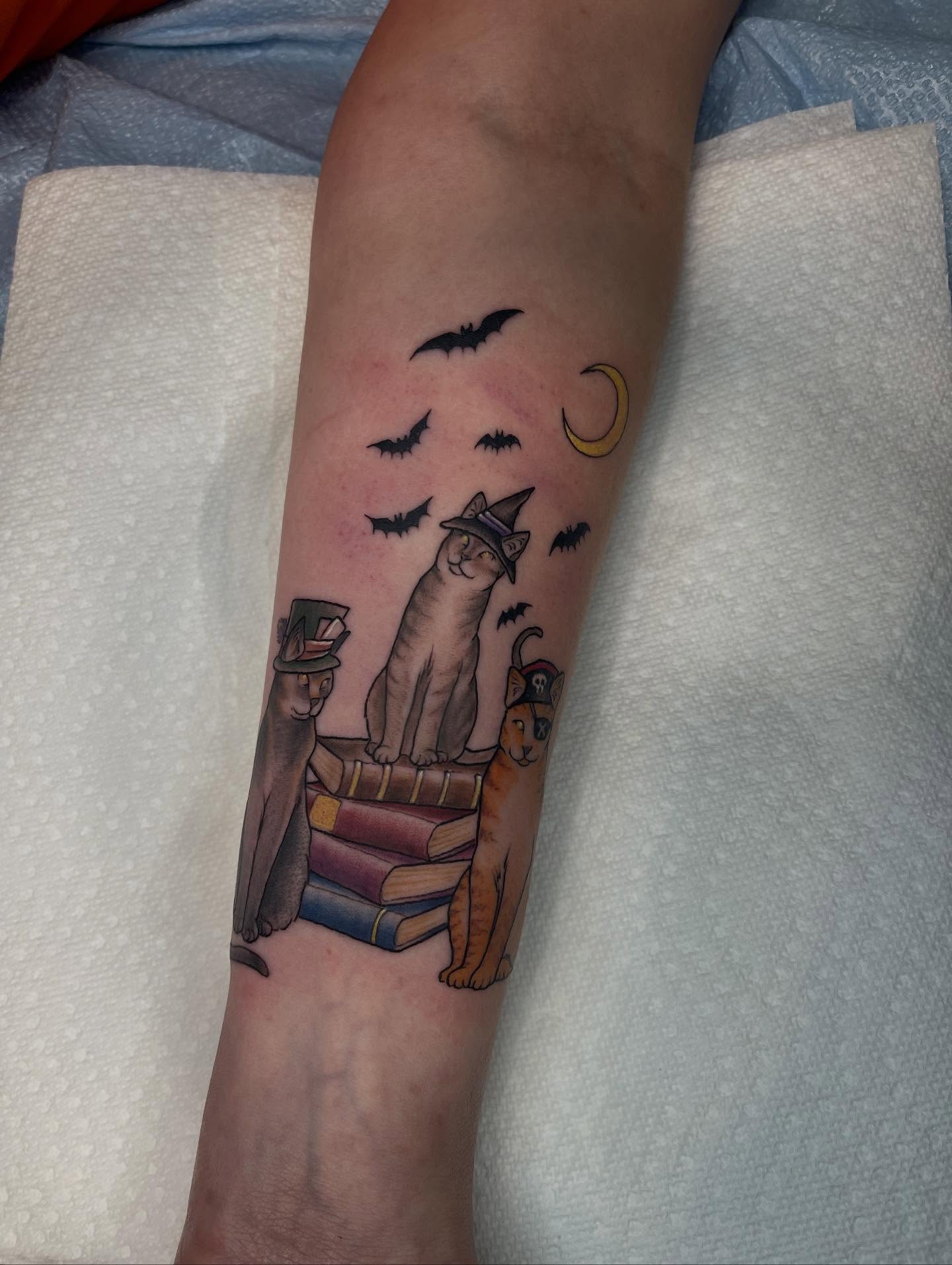 Cats and books realism tattoo on the forearm by Allison Gallagher