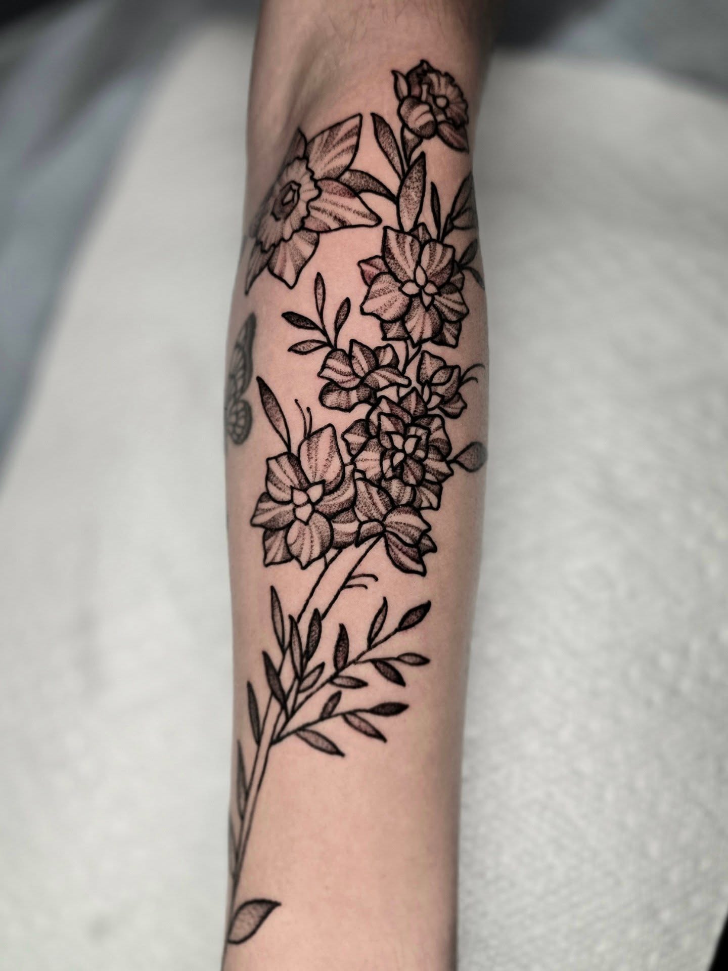 Floral bouquet black and grey tattoo on the forearm by Adison Essig