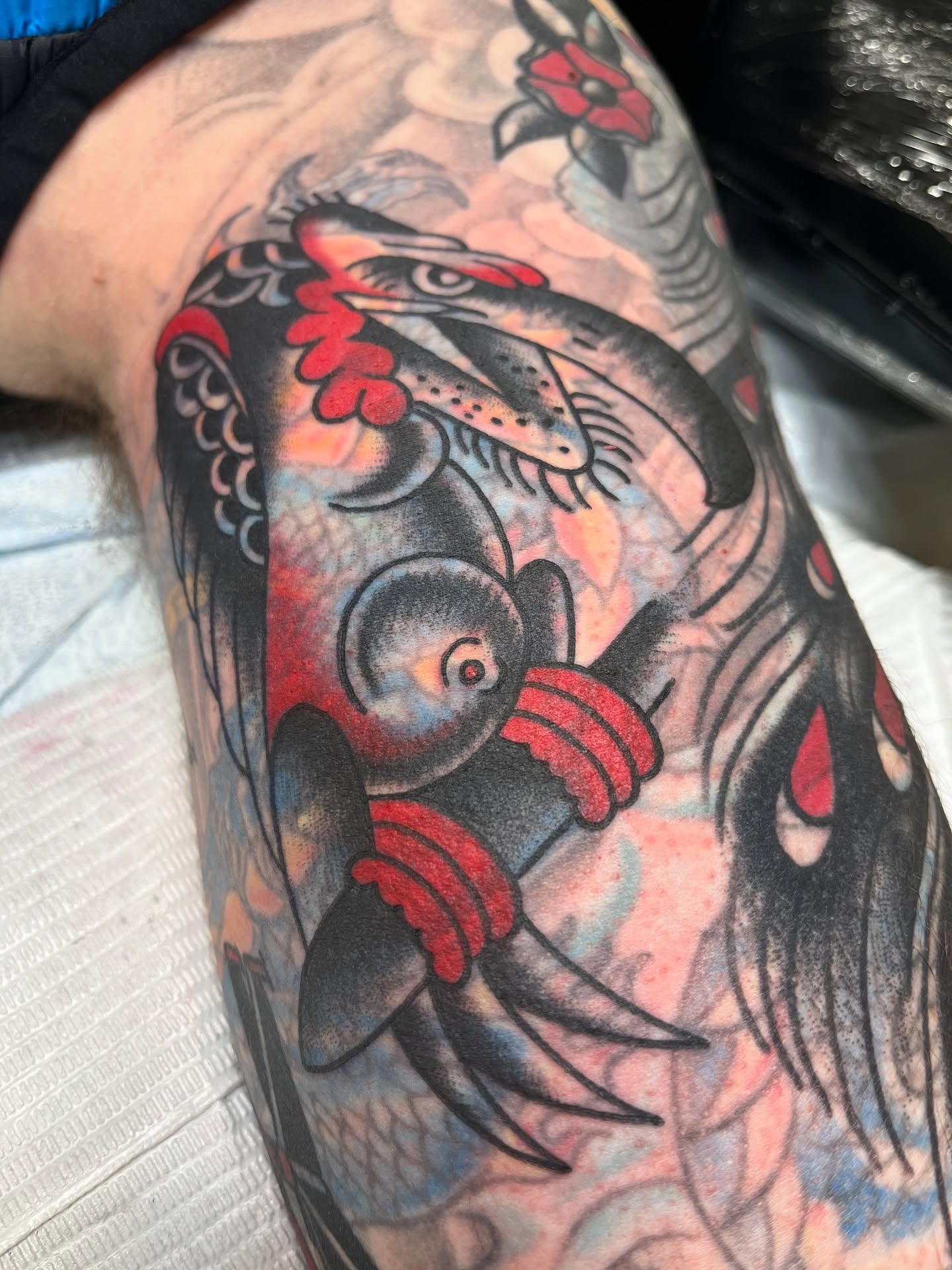 Bird and flower American traditional tattoo on the upper arm by Tim Howell