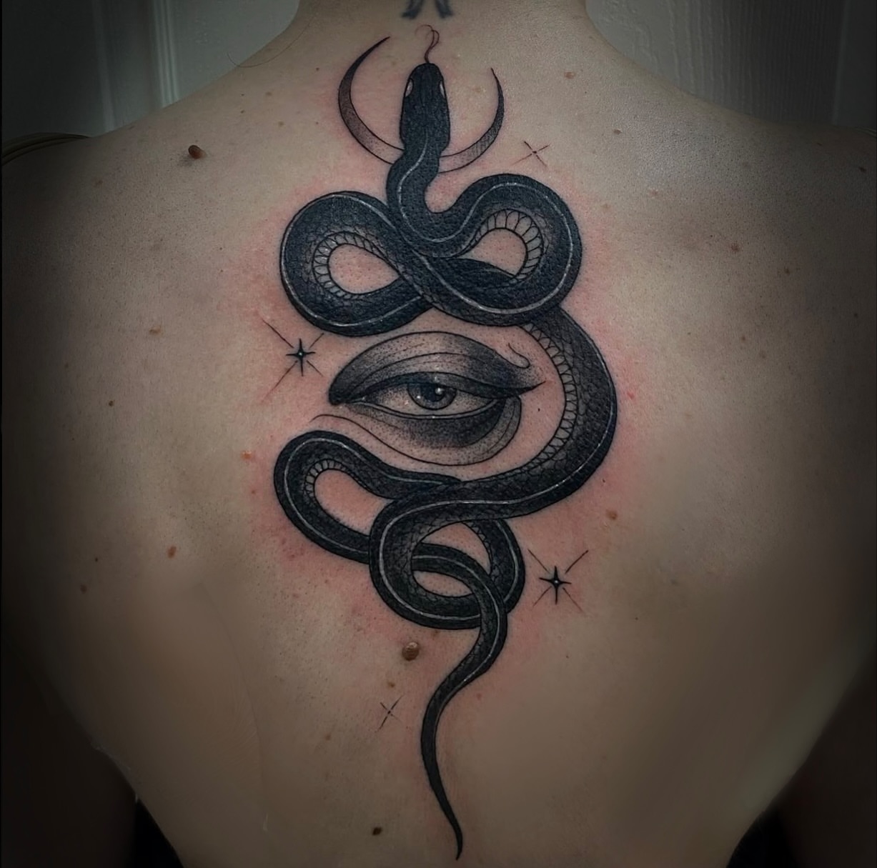 Snake and eye realism tattoo on the back by Marissa Tattoos