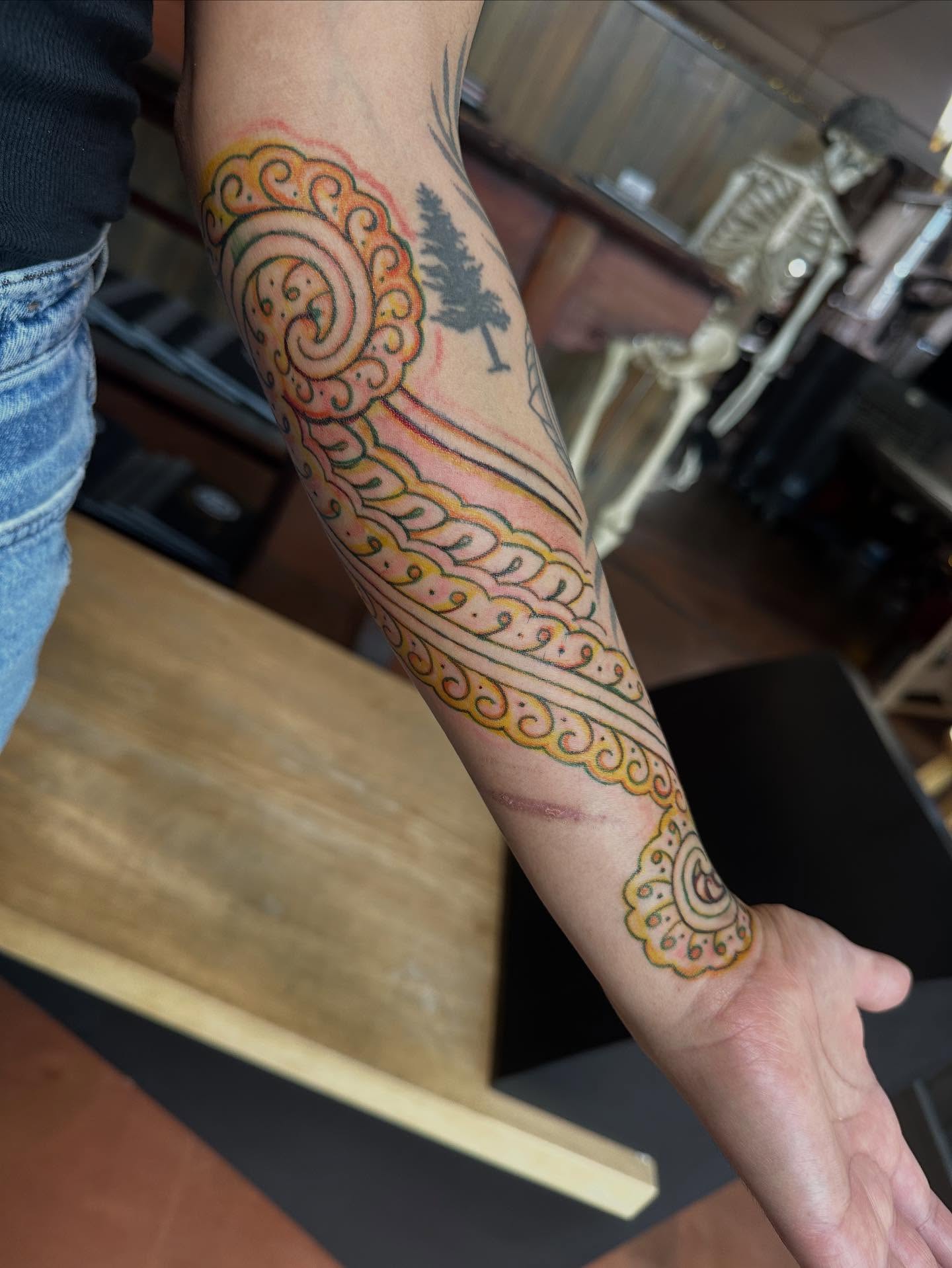 Scrollwork and tree ornamental tattoo on the forearm by Owlyn Madrone