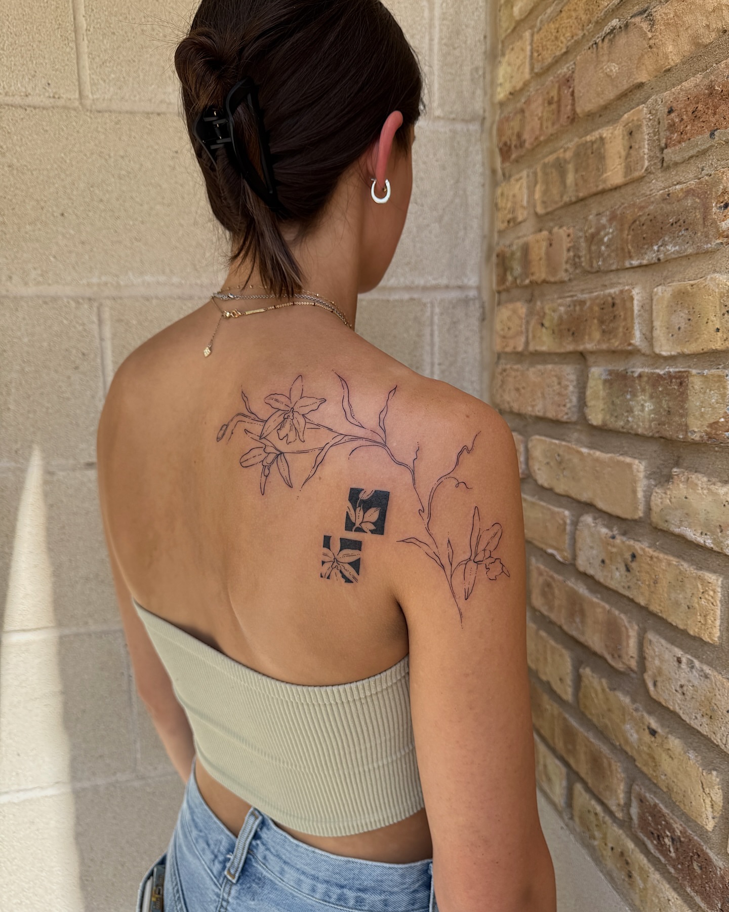 Floral branch fine line tattoo on the back by Inky Apricot, Austin, Texas