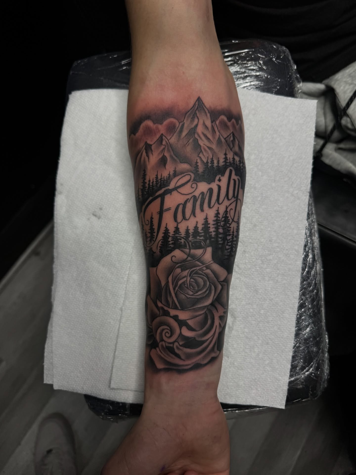 Mountains and roses realism tattoo on the forearm by Zeus