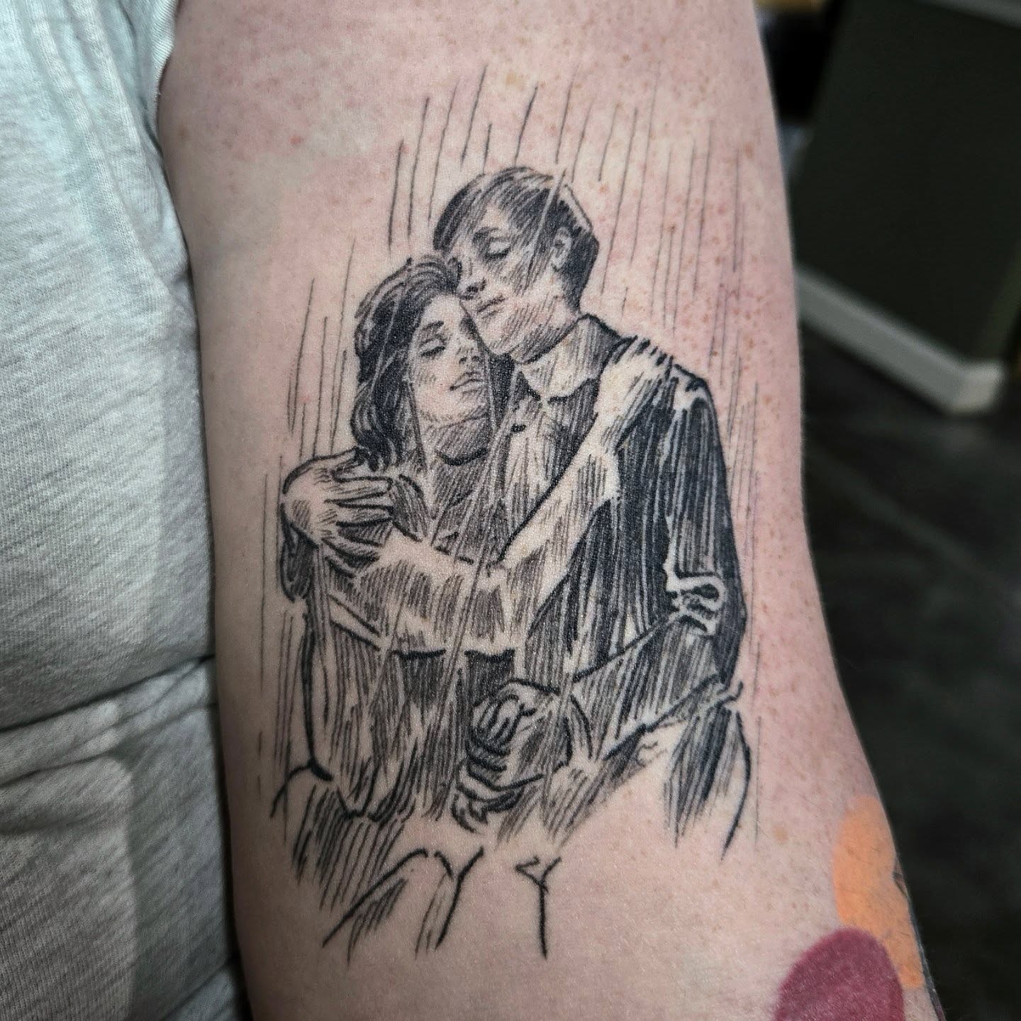Couple in rain realism tattoo on the forearm by Amanda Hinrichs